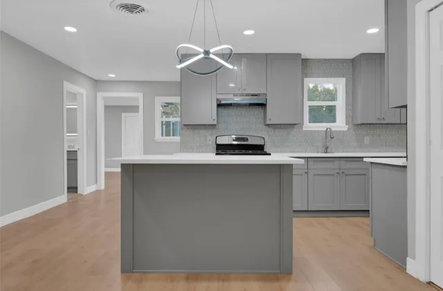 a kitchen with stainless steel appliances a sink stove and cabinets