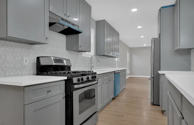 a kitchen with stainless steel appliances a sink a stove and a refrigerator