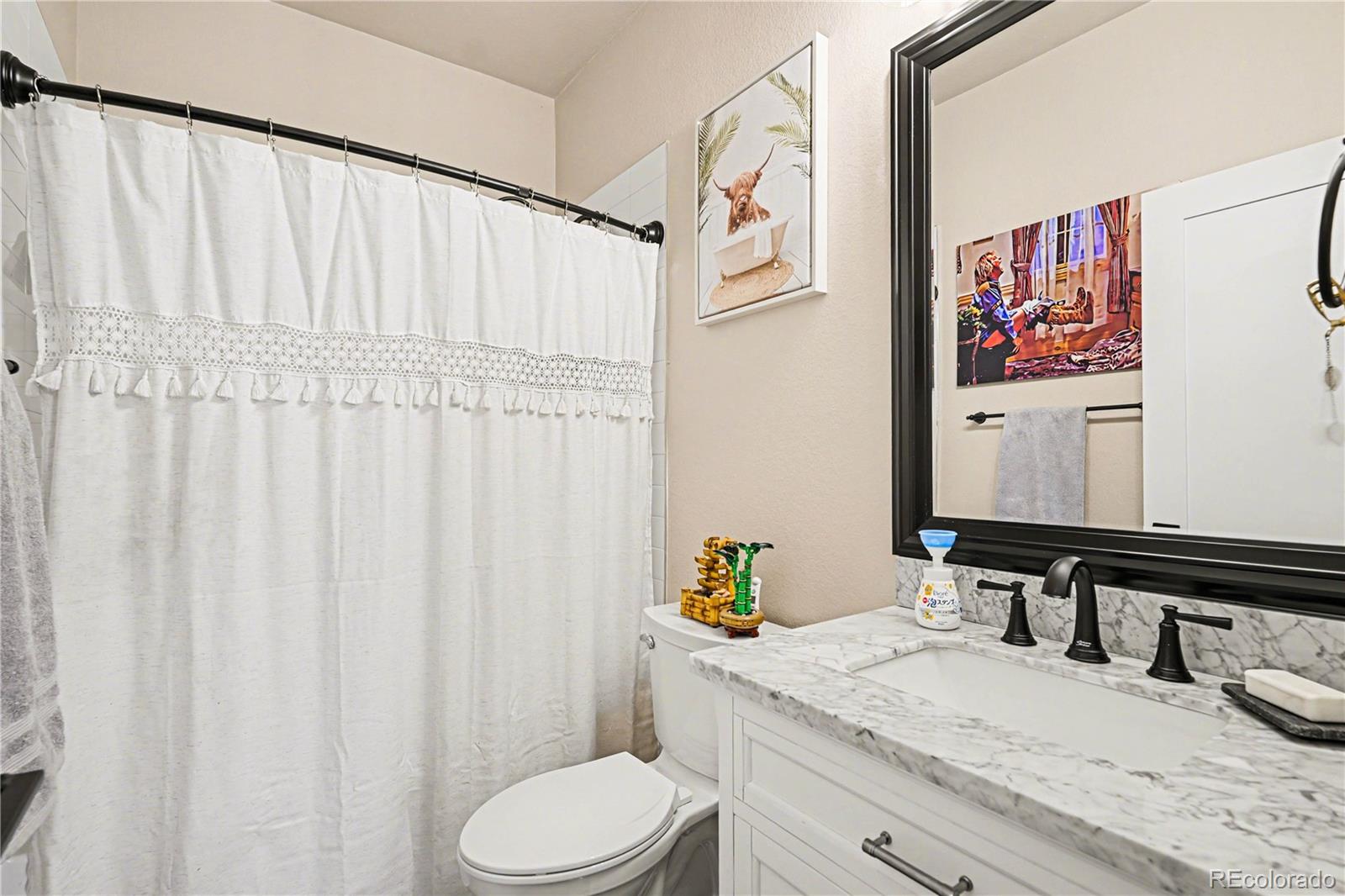 1065 Rising Sun Avenue Elizabeth, CO 80107 - Photo 12 of 37 a bathroom with a granite countertop sink and a mirror