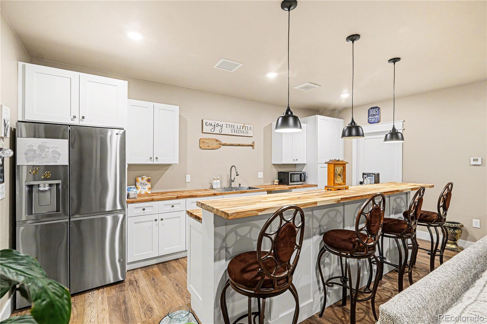 1065 Rising Sun Avenue Elizabeth, CO 80107 - Photo 16 of 37 a kitchen with stainless steel appliances a dining table chairs sink refrigerator and microwave
