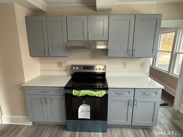 a kitchen with stainless steel appliances granite countertop a stove a cabinets and a refrigerator
