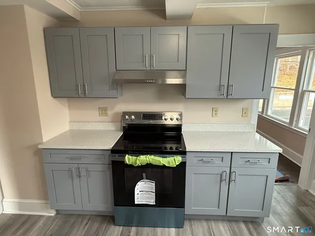 a kitchen with stainless steel appliances granite countertop a stove a cabinets and a refrigerator