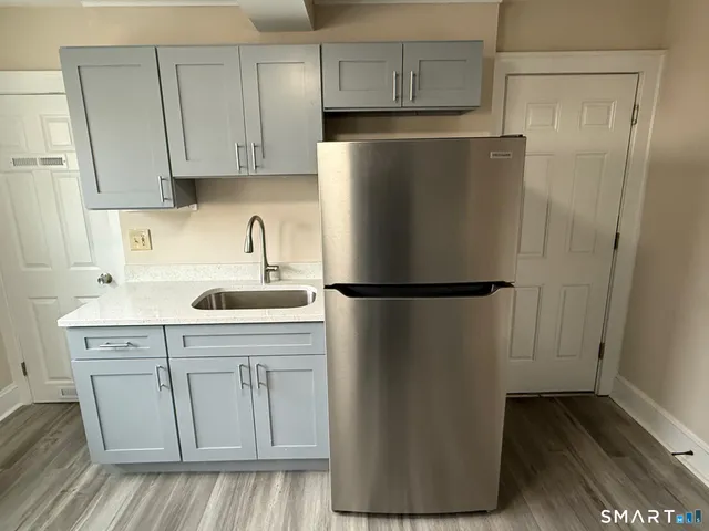 a kitchen with a refrigerator sink and cabinets
