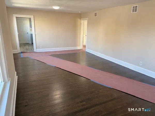 a view of a room with wooden floor