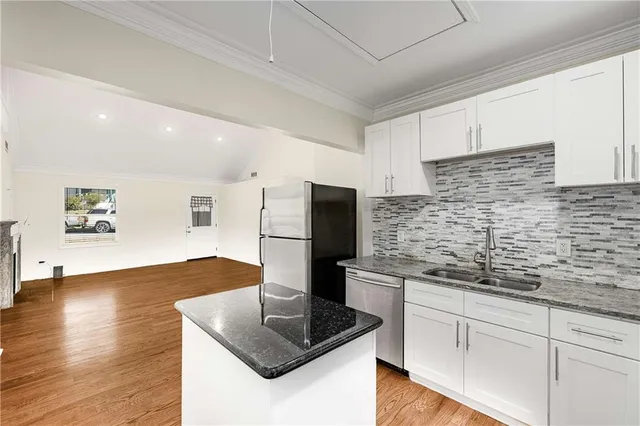 a kitchen with stainless steel appliances granite countertop a sink and a refrigerator