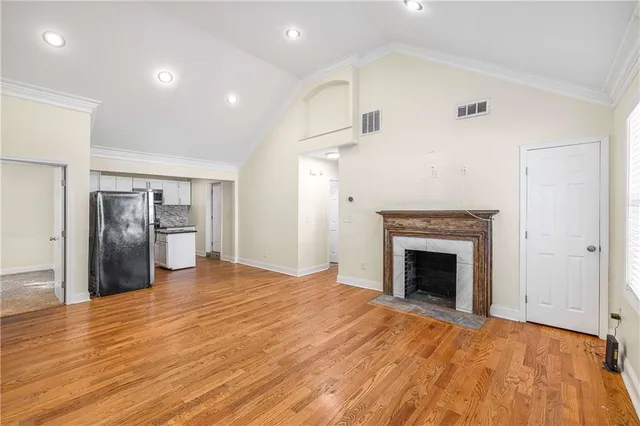 a view of empty room with wooden floor and fireplace