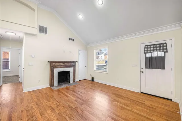 a view of empty room with wooden floor and fireplace