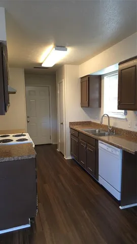 a kitchen with granite countertop a stove and a wooden floor