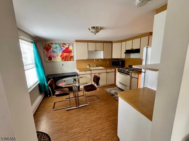 a work room with wooden floor furniture and a window