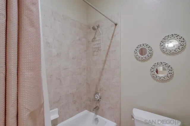a bathroom with a toilet and a shower curtain