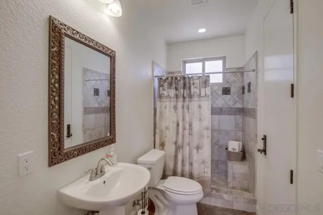 a bathroom with a sink toilet and shower