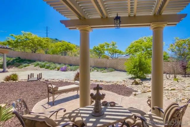 a view of a patio with table and chairs potted plants