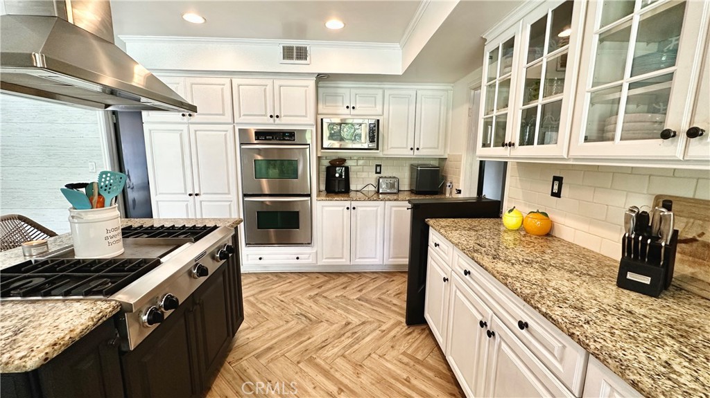 19559 Tulsa Street Porter Ranch, CA 91326 - Photo 20 of 55 a kitchen with stainless steel appliances granite countertop a stove and a sink