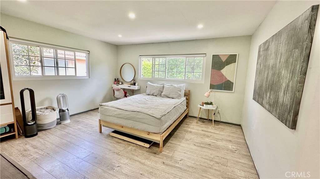 19559 Tulsa Street Porter Ranch, CA 91326 - Photo 29 of 55 a spacious bedroom with a bed a dresser and a window with wooden floor