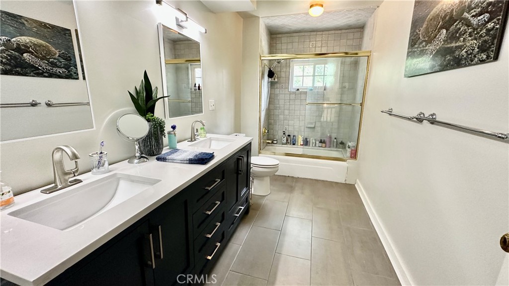 19559 Tulsa Street Porter Ranch, CA 91326 - Photo 30 of 55 a bathroom with a double vanity sink a toilet and shower