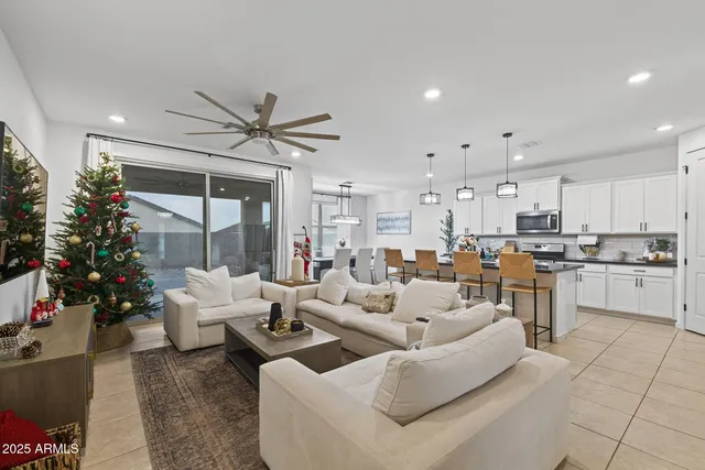 a living room with furniture kitchen view and a large window