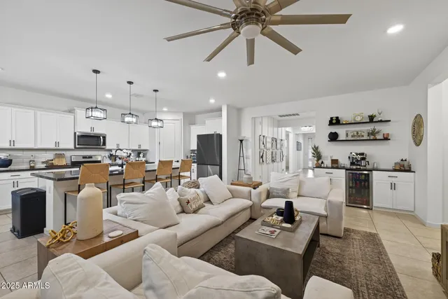 a living room with furniture kitchen view and a chandelier