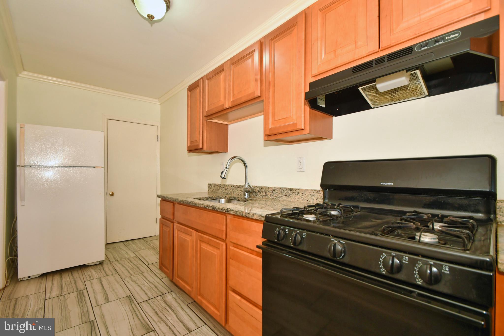 731 Roundview Road Baltimore, MD 21225 - Photo 14 of 40 a kitchen with granite countertop a stove and a refrigerator