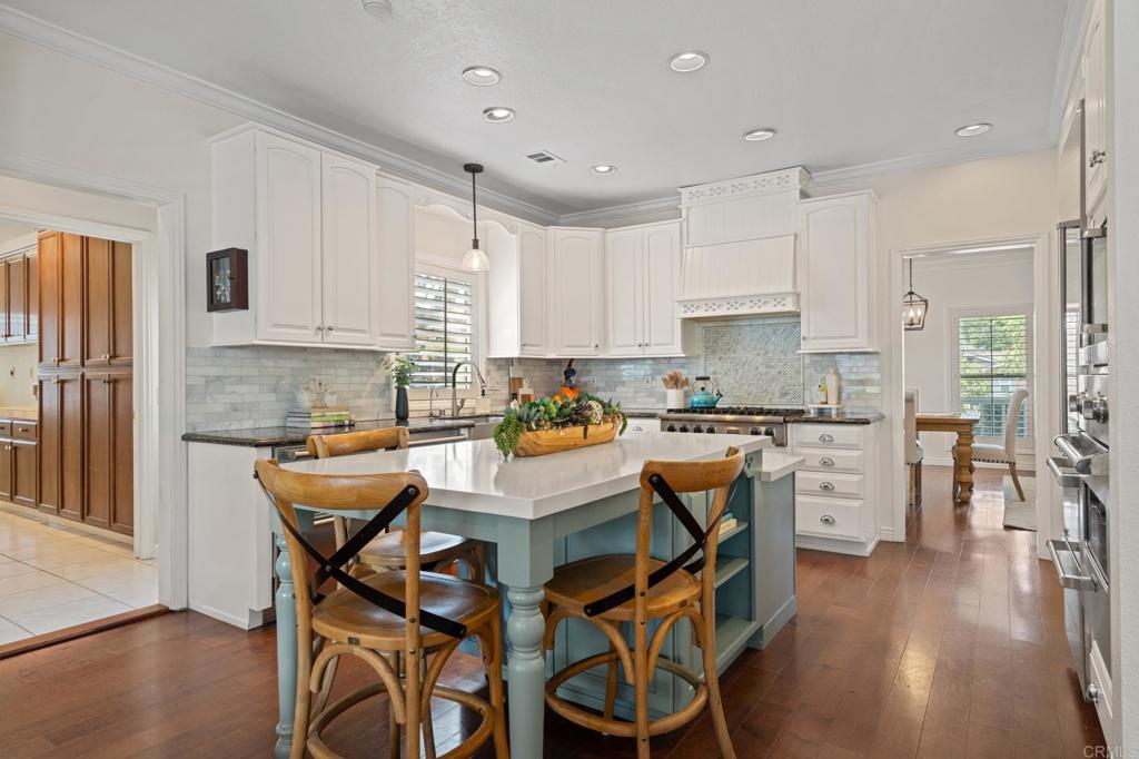 14403 Gaslight Court Poway, CA 92064 - Photo 15 of 58 a kitchen with white cabinets and stainless steel appliances