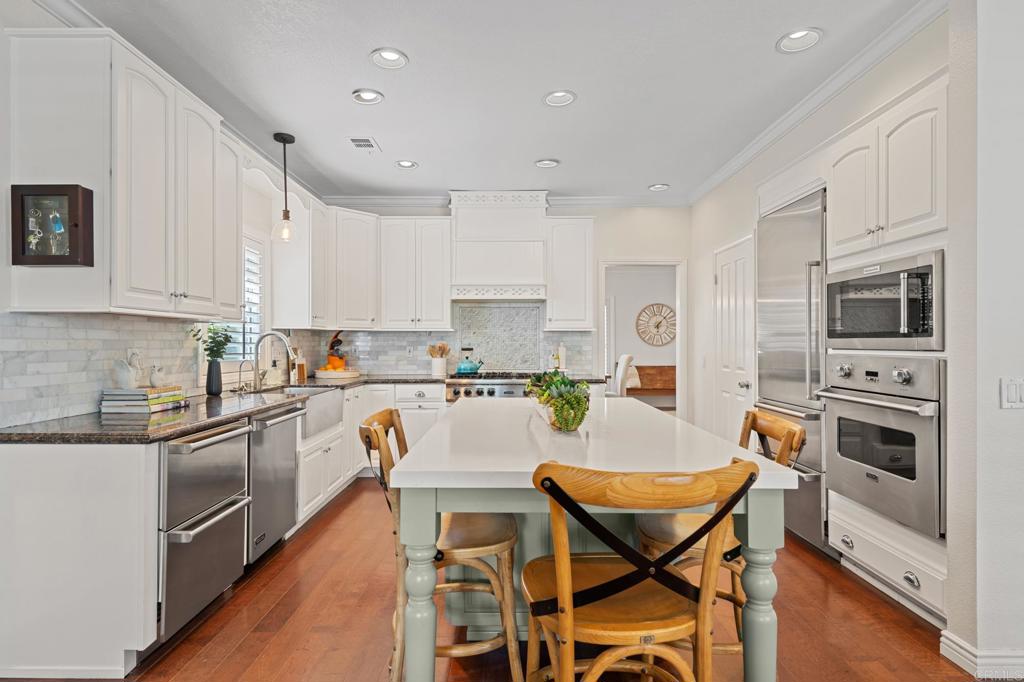 14403 Gaslight Court Poway, CA 92064 - Photo 16 of 58 a kitchen with a dining table chairs and microwave