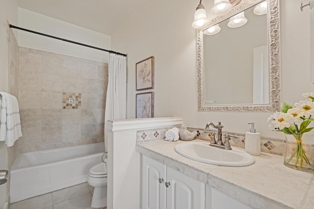 14403 Gaslight Court Poway, CA 92064 - Photo 21 of 58 a bathroom with a sink a toilet and a large mirror