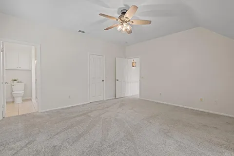 a spacious bedroom with a bed and a chandelier