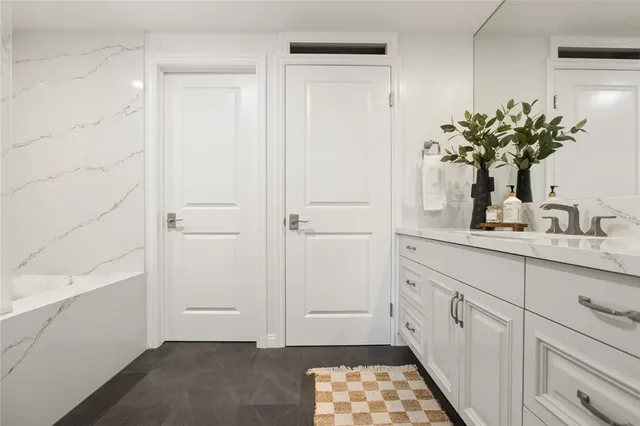 a bathroom with a sink a mirror and a potted plant