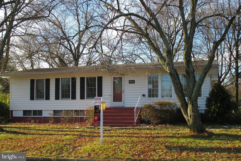 a view of a house with large trees in front of it