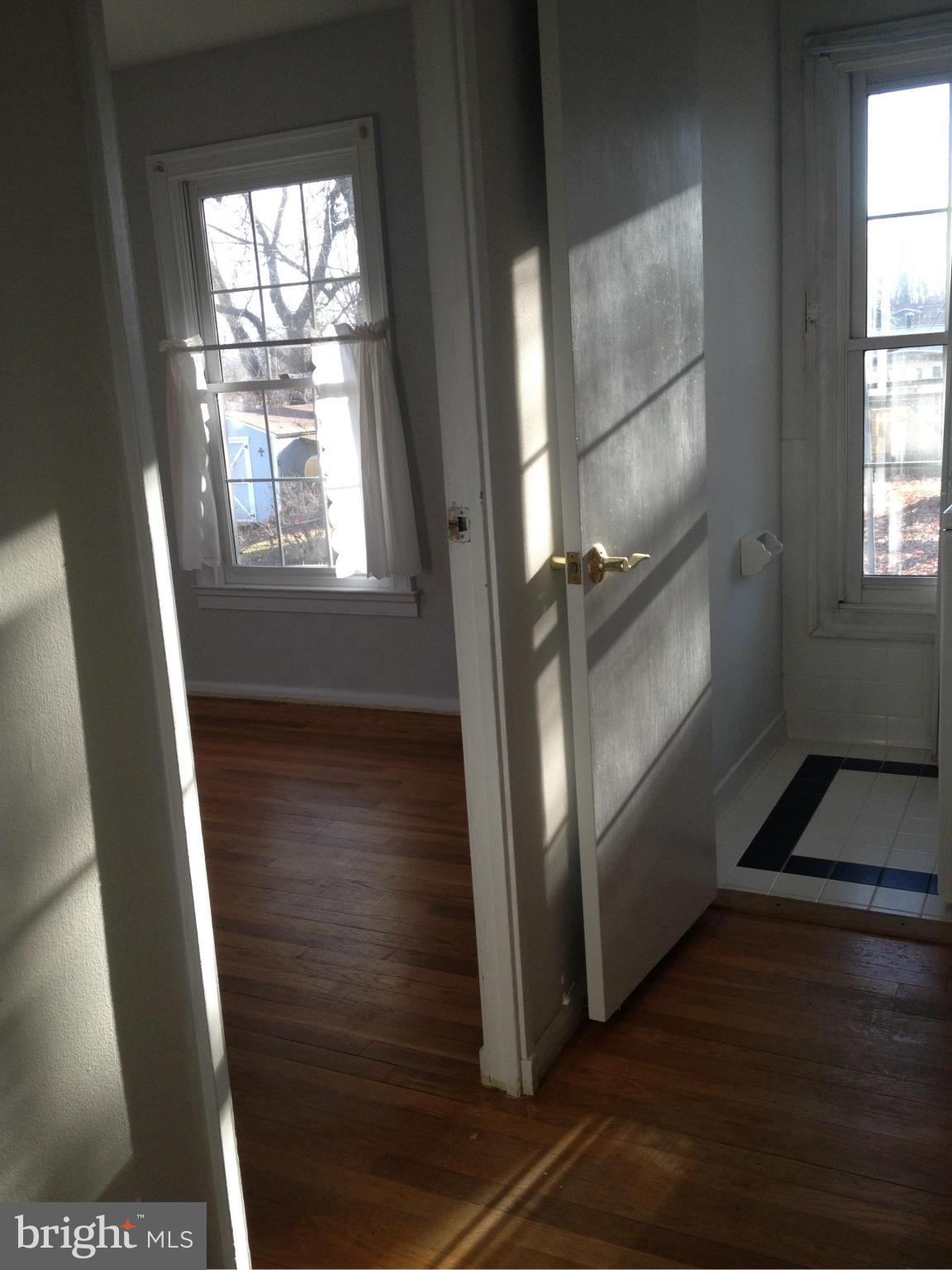 10213 Rodgers Road Fairfax, VA 22030 - Photo 3 of 26 a view of an empty room with wooden floor and a window