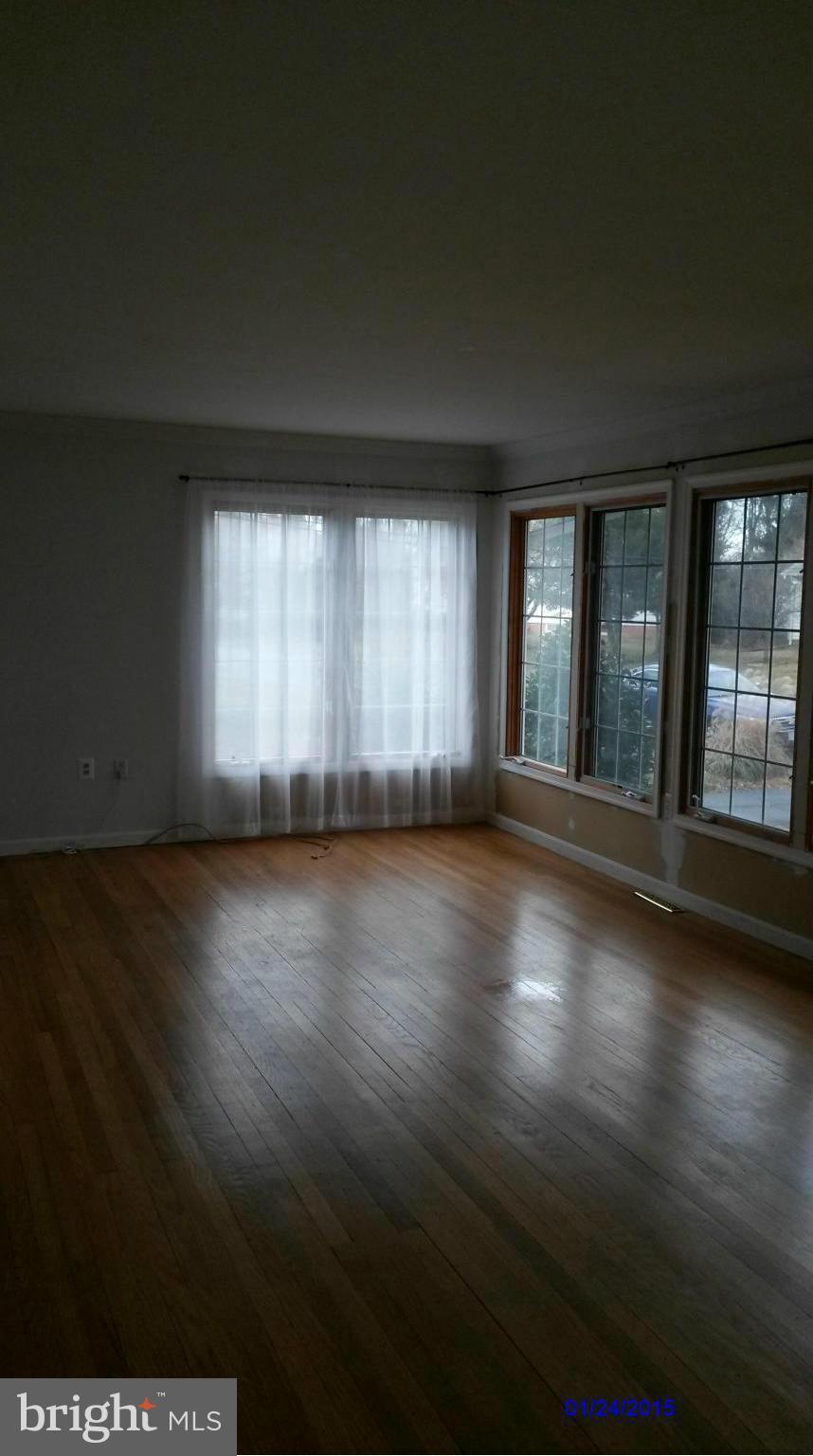 10213 Rodgers Road Fairfax, VA 22030 - Photo 4 of 26 a view of an empty room with wooden floor and a window