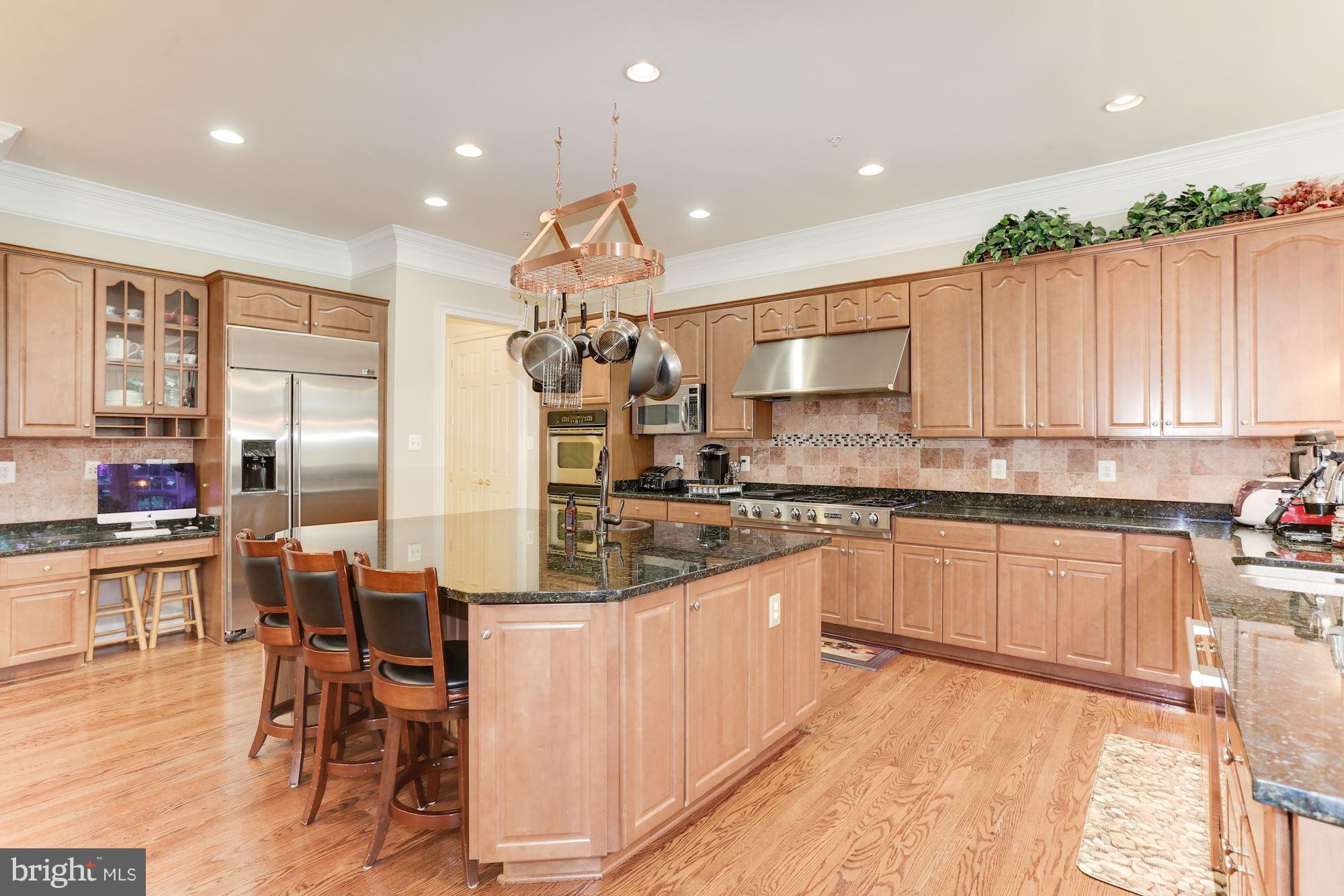 9204 Jones Mill Road Chevy Chase, MD 20815 - Photo 12 of 50 a kitchen with stainless steel appliances a table and chairs in it