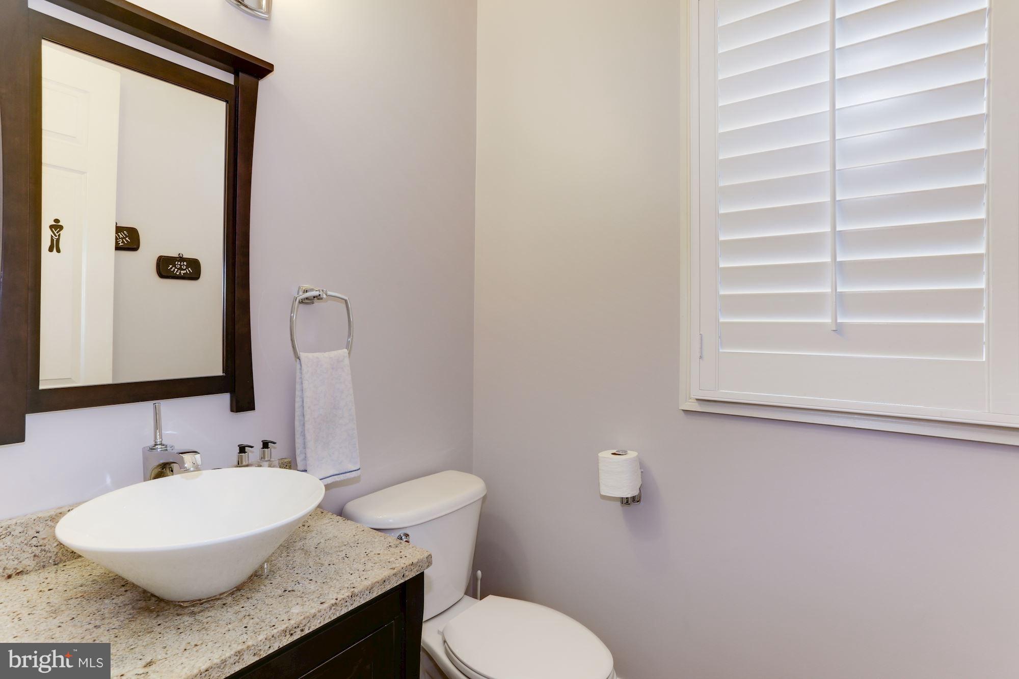 9204 Jones Mill Road Chevy Chase, MD 20815 - Photo 20 of 50 a bathroom with a granite countertop sink and a mirror