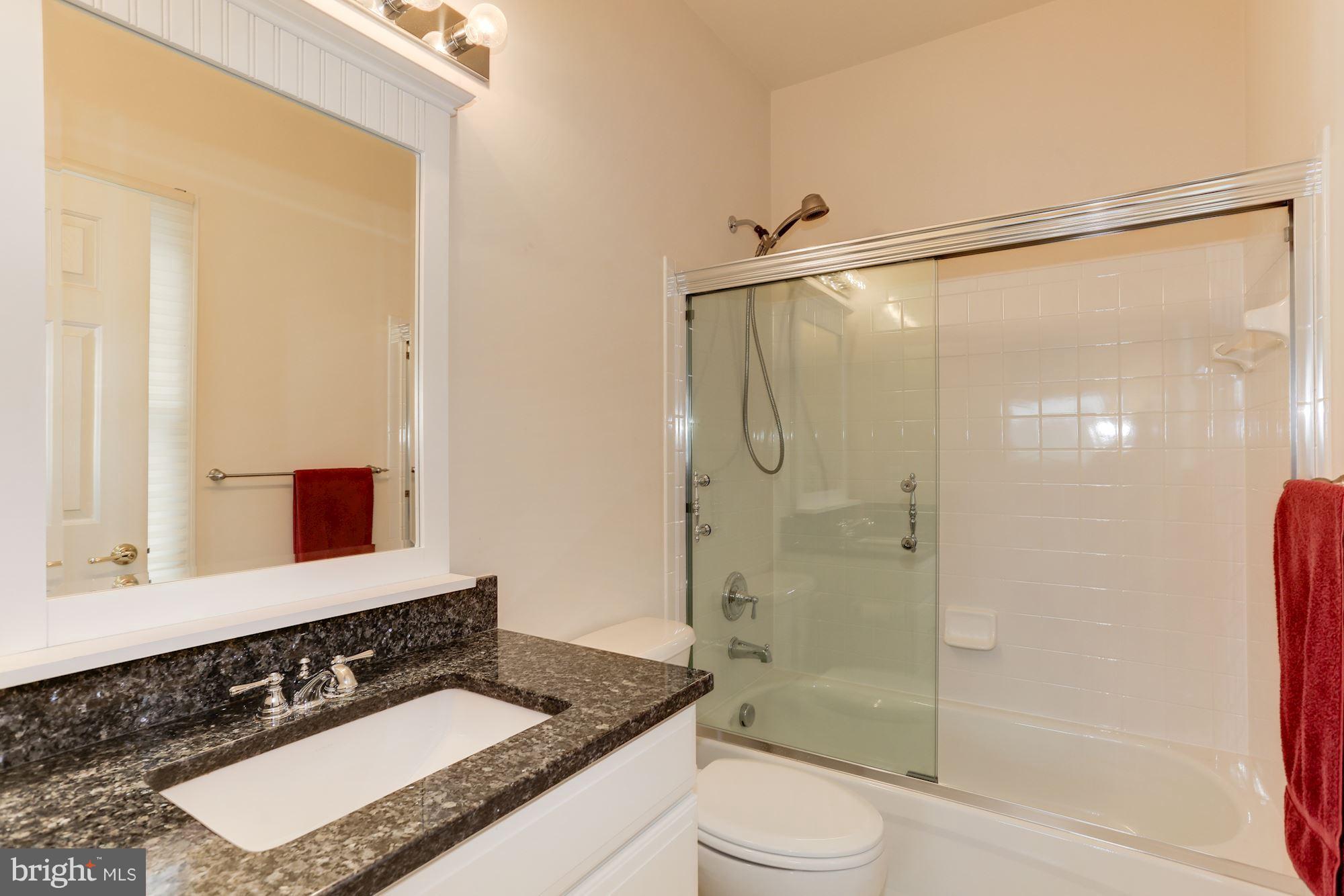 9204 Jones Mill Road Chevy Chase, MD 20815 - Photo 28 of 50 a bathroom with a granite countertop sink mirror toilet and shower