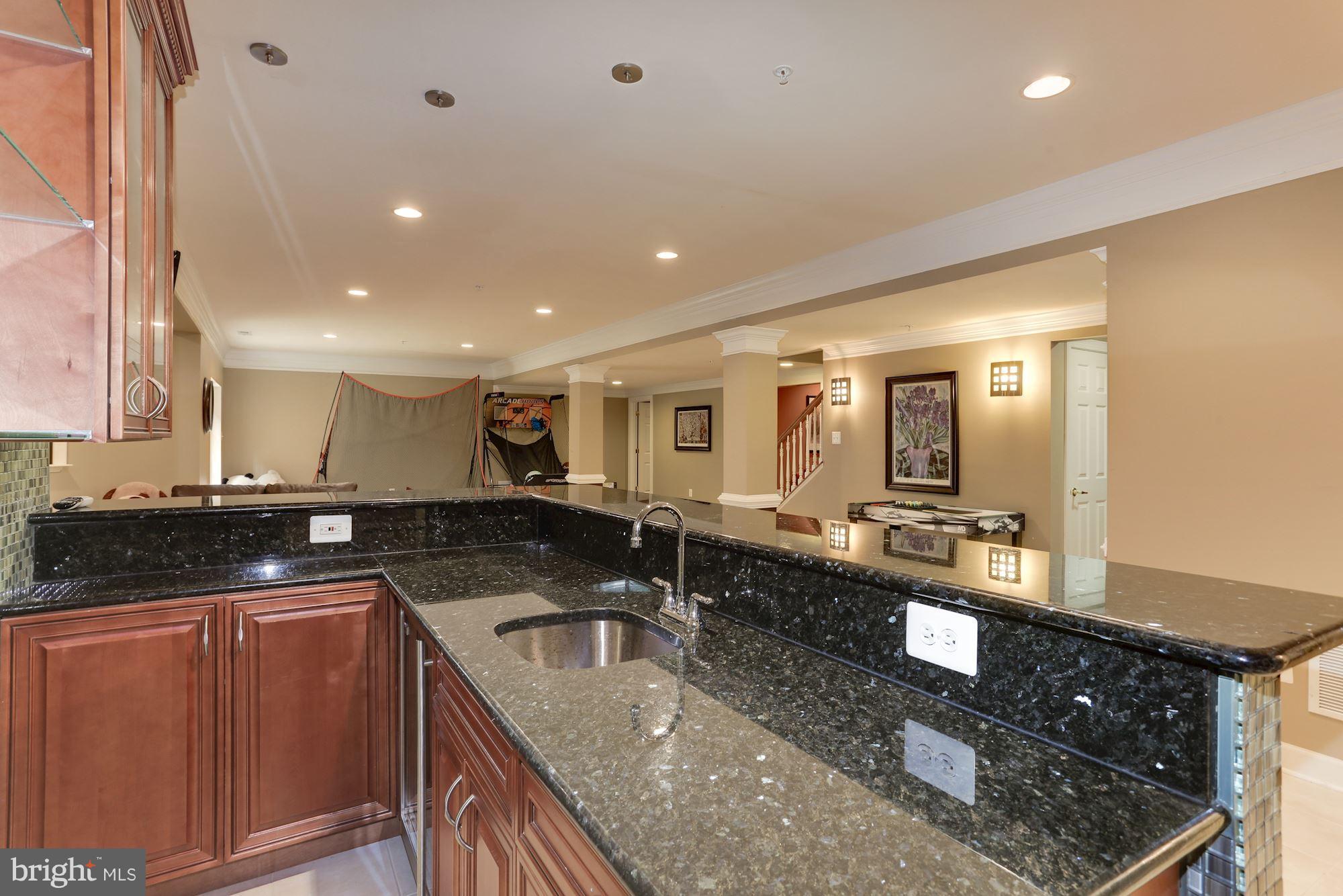 9204 Jones Mill Road Chevy Chase, MD 20815 - Photo 36 of 50 a kitchen with stainless steel appliances granite countertop a sink a stove and a wooden cabinets