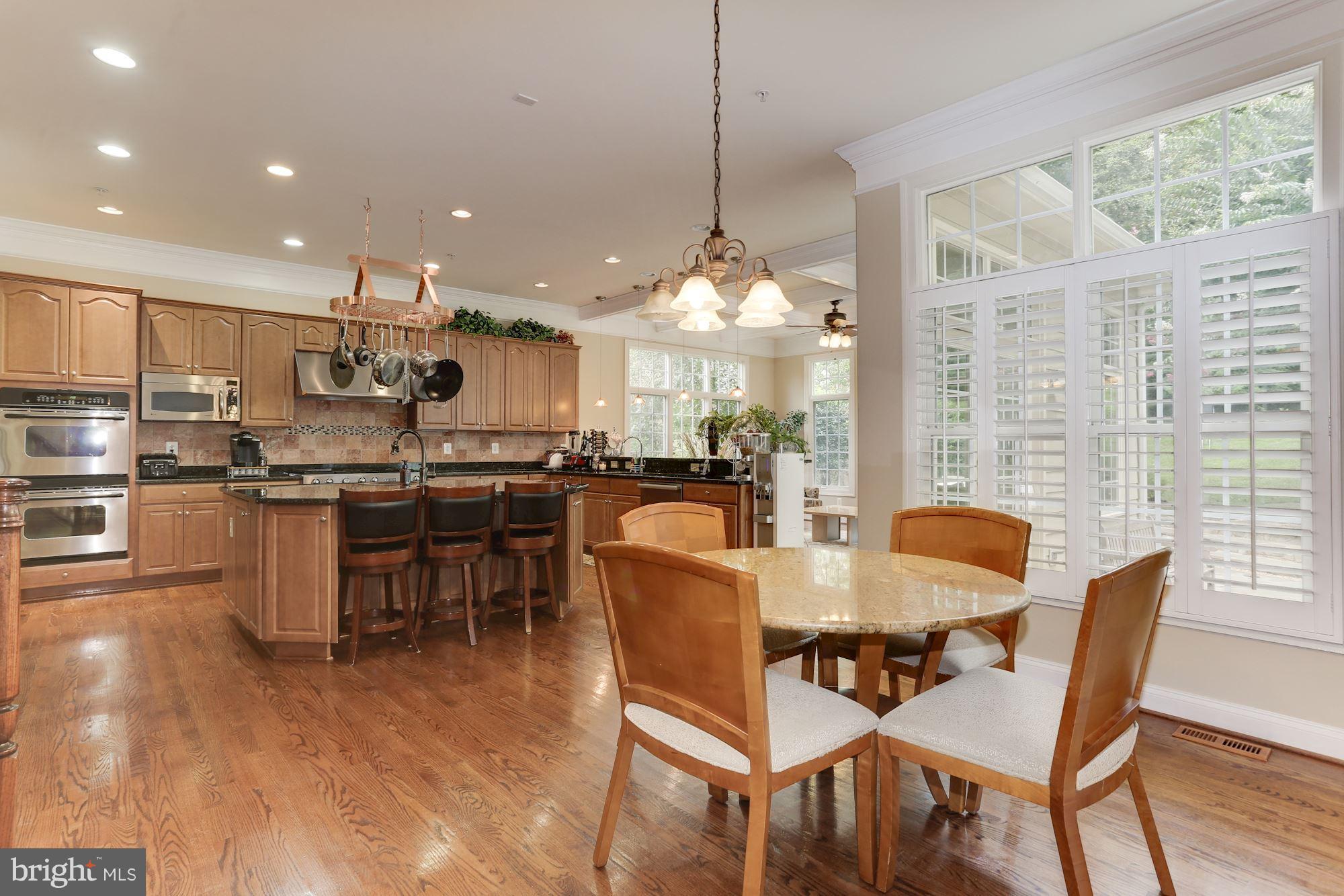 9204 Jones Mill Road Chevy Chase, MD 20815 - Photo 10 of 50 a dining room with stainless steel appliances kitchen island granite countertop a stove a kitchen island a dining table and chairs