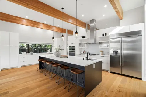 a kitchen with stainless steel appliances granite countertop a sink a oven and a refrigerator