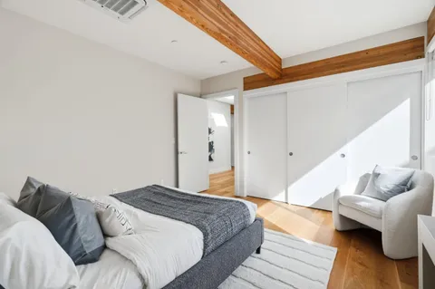 a bedroom with a bed and wooden floor