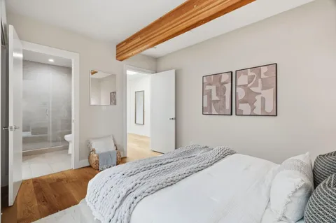 a bedroom with a bed and a painting on the wall