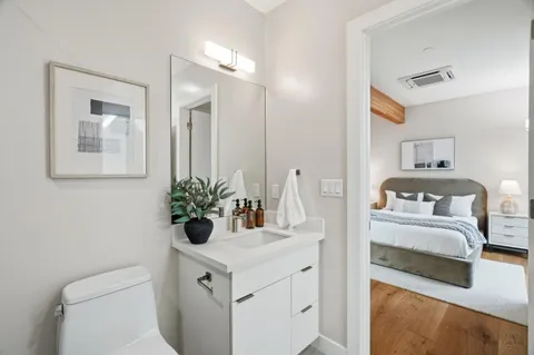 a bathroom with a sink a toilet and a mirror