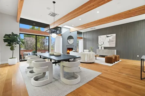 a living room with furniture a large window and potted plants