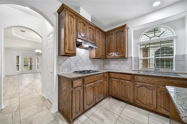 a kitchen with stainless steel appliances granite countertop a stove and cabinets