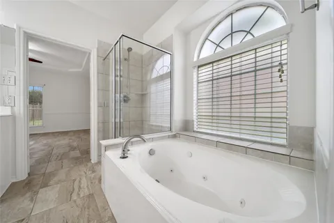 a bathroom with a tub sink and mirror