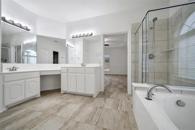 a spacious bathroom with a double vanity sink a mirror and a bathtub