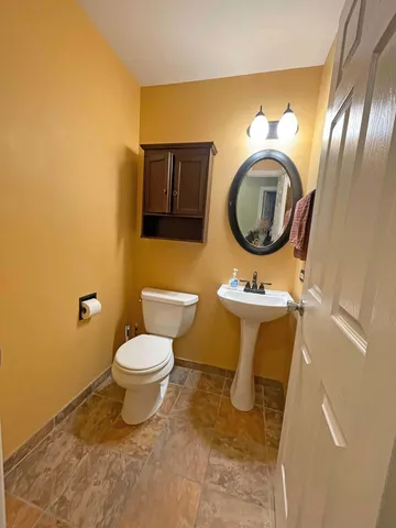 a bathroom with a toilet sink and mirror