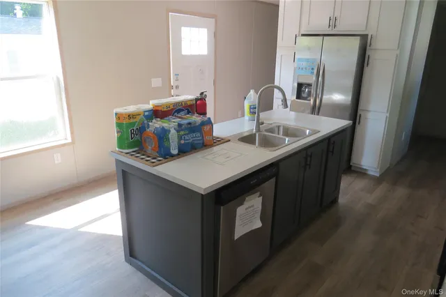 a kitchen with a sink a microwave a dining table and chairs