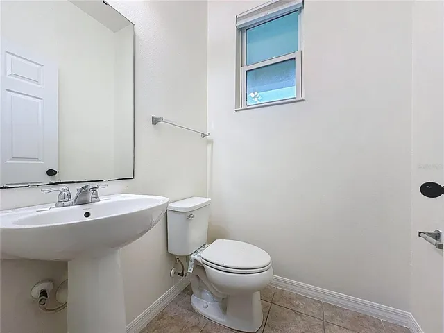 a bathroom with a sink and mirror with toilet