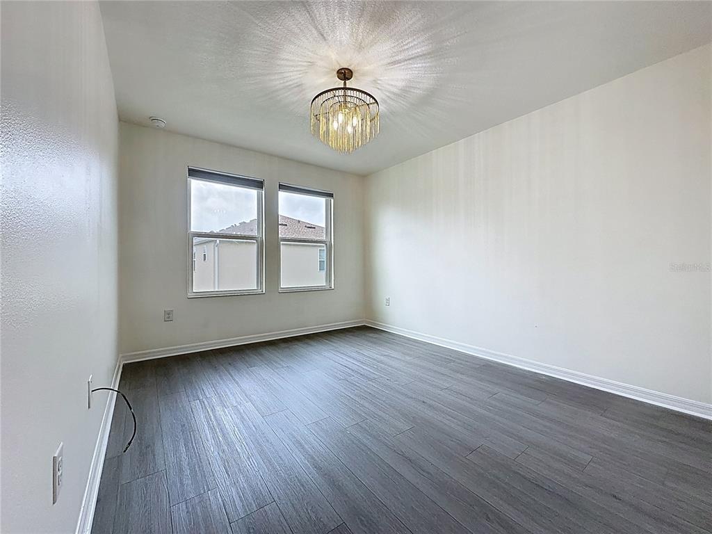 3135 Tocoa Circle Kissimmee, FL 34746 - Photo 26 of 36 a view of an empty room with a window and wooden floor