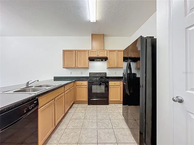 a kitchen with a refrigerator and a sink