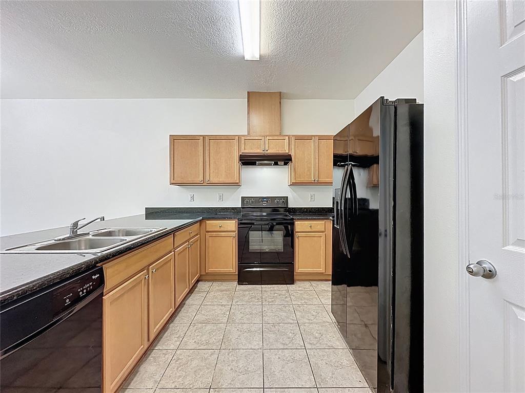 3135 Tocoa Circle Kissimmee, FL 34746 - Photo 3 of 36 a kitchen with a refrigerator and a sink