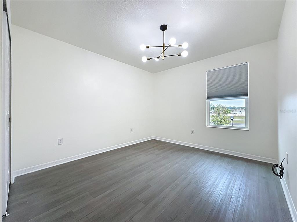 3135 Tocoa Circle Kissimmee, FL 34746 - Photo 31 of 36 a view of an empty room with wooden floor and a window